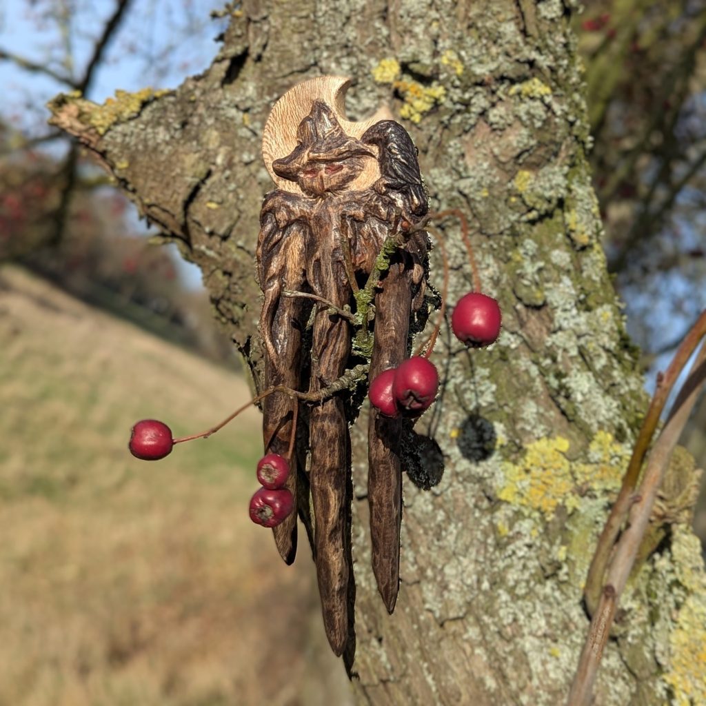 Handgeschnitzte Platanenholz Haarforke „Haunted Best Friend“ mit detailreiner Schnitzerei einer Vogelscheuche und einer Krähe vor einer Mondsichel, ergonomisch gebogen für feines Haar.