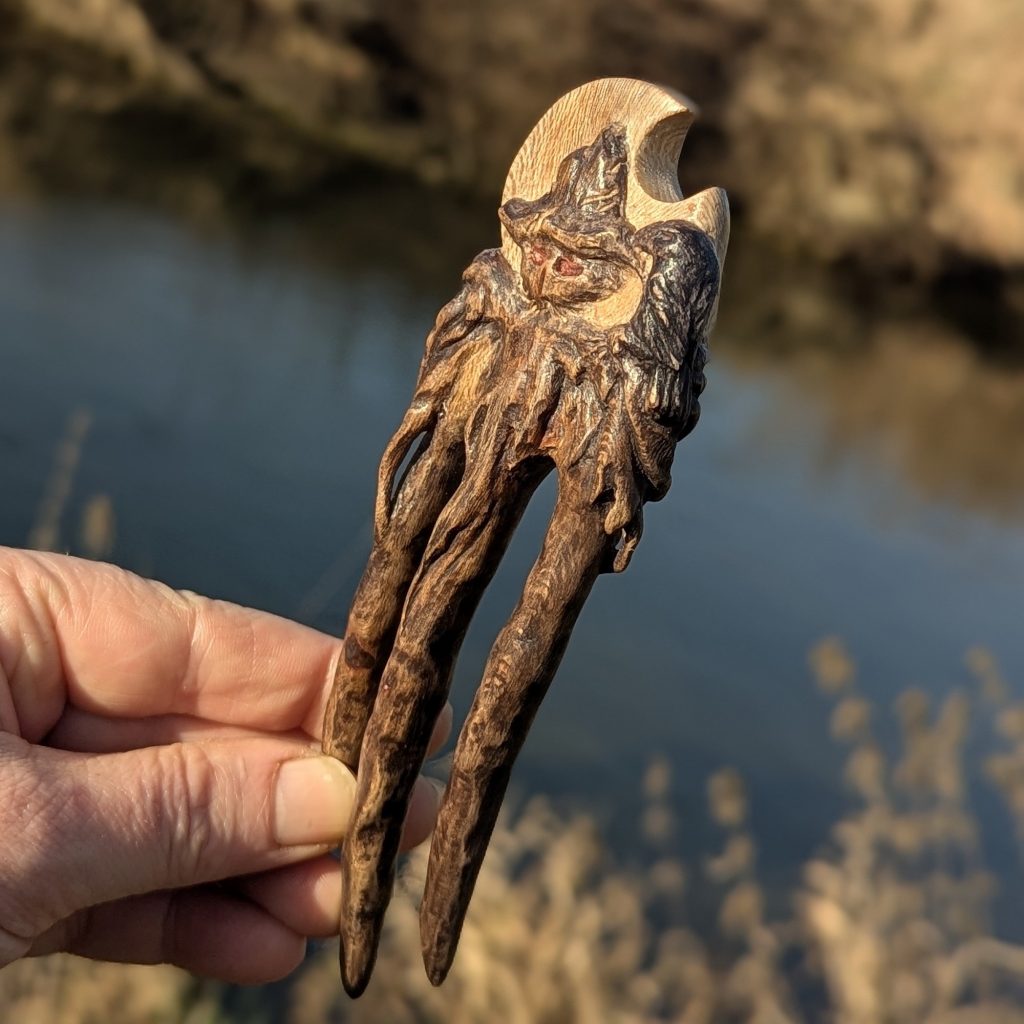 Handgeschnitzte Platanenholz Haarforke „Haunted Best Friend“ mit detailreiner Schnitzerei einer Vogelscheuche und einer Krähe vor einer Mondsichel, ergonomisch gebogen für feines Haar. rabe, haarschmuck schnitzerin