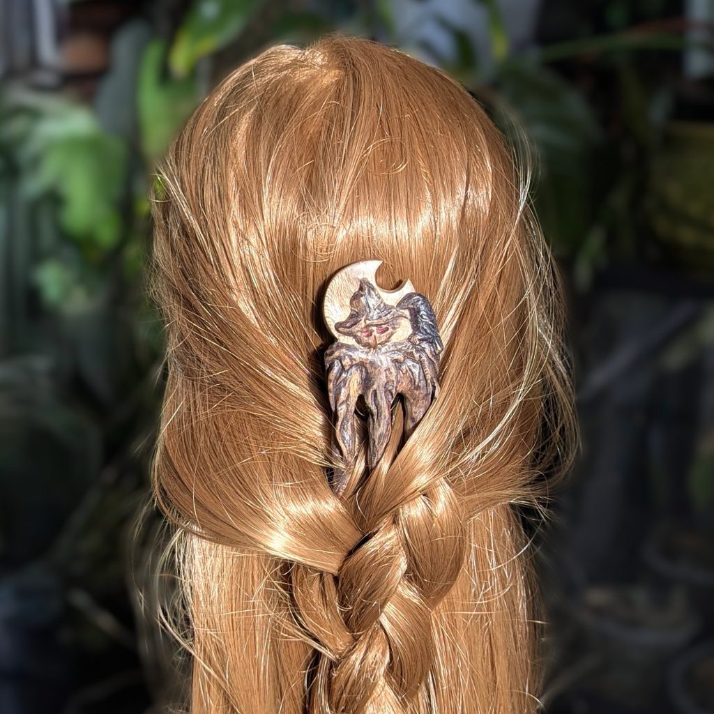 Handgeschnitzte Platanenholz Haarforke „Haunted Best Friend“ mit detailreiner Schnitzerei einer Vogelscheuche und einer Krähe vor einer Mondsichel, ergonomisch gebogen für feines Haar.